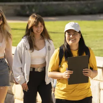 Students with orientation guide walking and smiling 